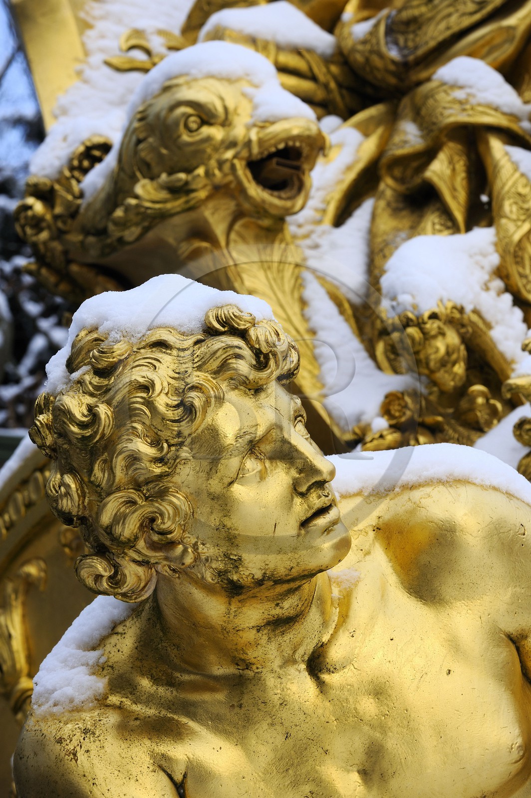 France, Yvelines, snow covered park of the Chateau de Versailles, listed as World Heritage by UNESCO, detail of a statue of the Triumphal Arch Grove