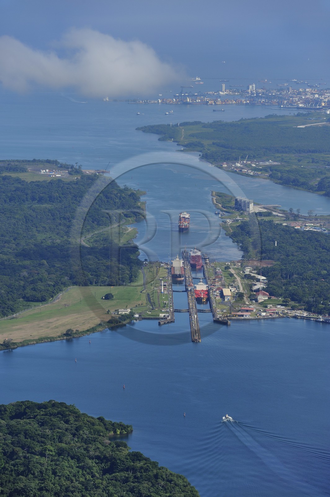 Panama, province de Colon, Canal de Panama, cargo Panamax passant les écluses de Gatun, la baie Limon (Bahia Limon) coté Atlantique et la ville de Colon en arrière plan (vue aérienne)