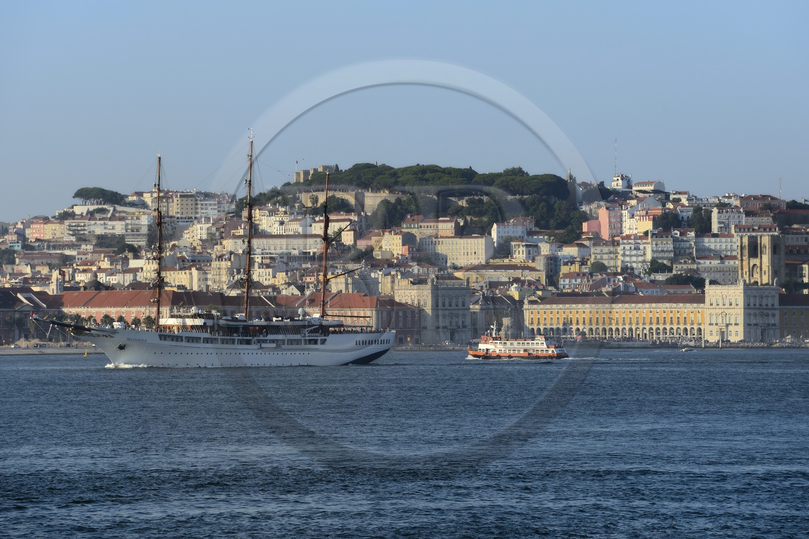 Portugal, Lisbon, the luxurious cruising yacht Sea Cloud II and a ferry on the Tagus river (rio Tejo) and the historical center in the background