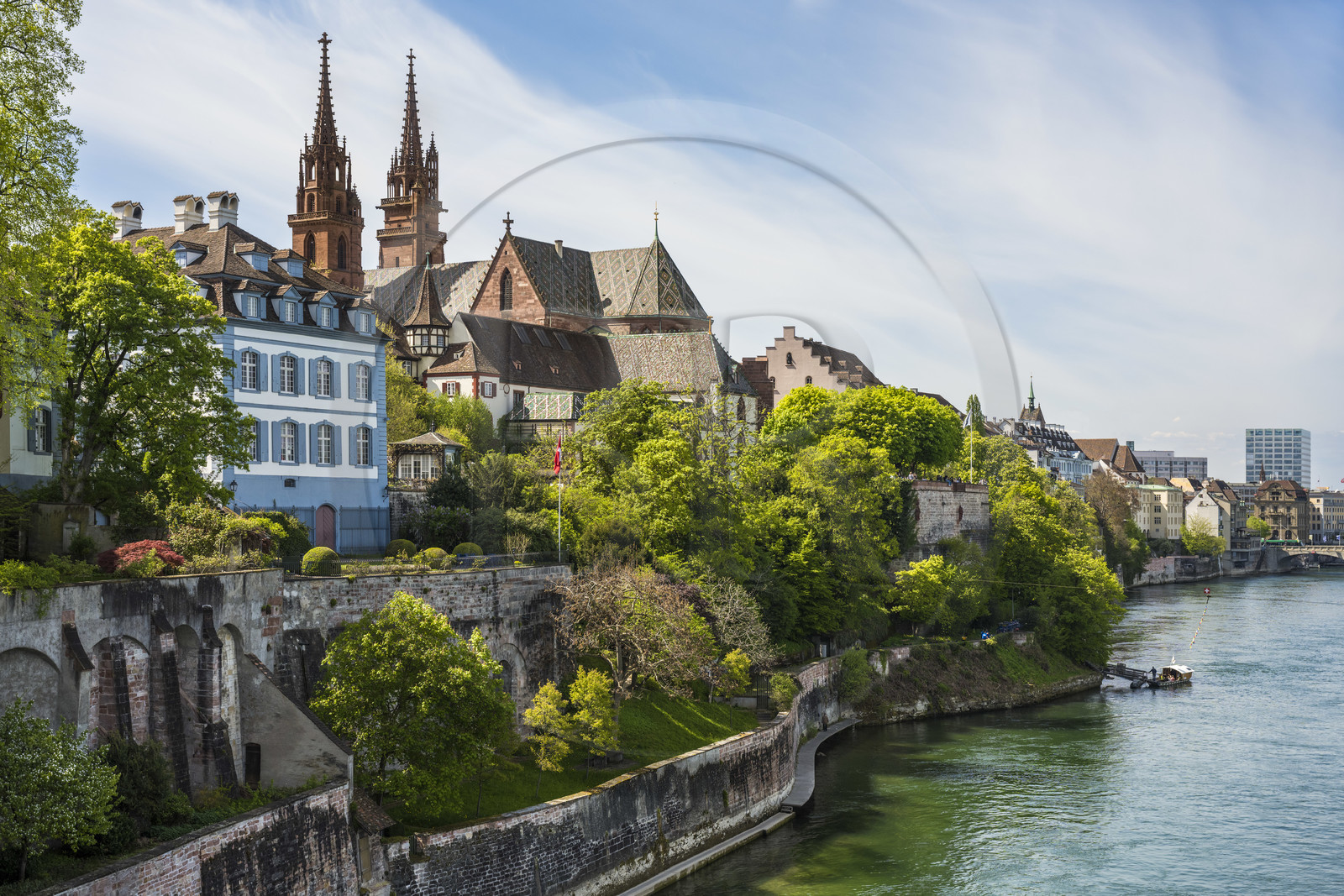 Switzerland, Basel, the left bank of the Rhine, the Minster or Protestant Cathedral of Our Lady of Basel (Munster) overlooking the Rhine and one of the four small ferries that connect the banks of the Rhine