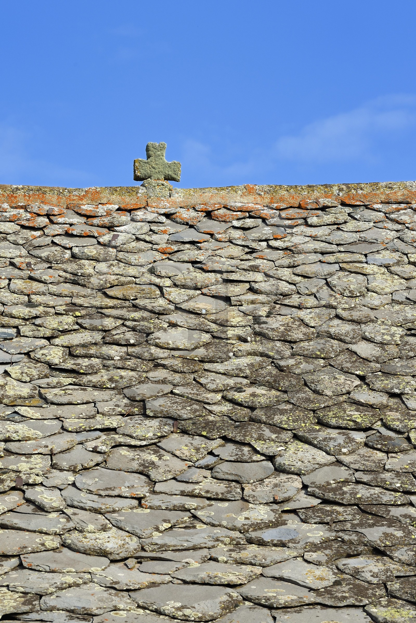France, Cantal, Parc Naturel Régional des Volcans d'Auvergne (regional nature park of Auvergne volcanoes), step on the Way of St. James to Santiago de Compostela by Via Arverna, Chalinargues, Mons hamlet, the stone cross surmounting the roof of the houses covered with lauze is one of the main traditional themes of protection