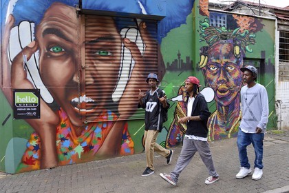 Afrique du Sud, province de Gauteng, Johannesburg, quartier de Braamfontein, groupe de jeunes devant un mur peint dans De Korte street