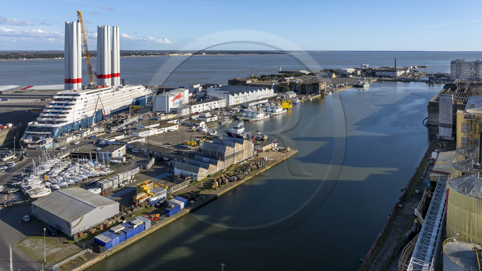 France, Loire Atlantique, Saint Nazaire, the construction site of the luxury super-yacht Ritz-Carlton Luminara in the Joubert dry dock, the wind turbine towers on the side are stored before embarkation (aerial view)