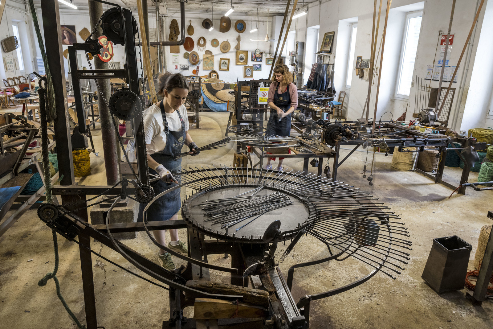 France, Drome, Drome provencale, Nyons, La Scourtinerie, the last scourtin factory in Provence, traditional filters used in the production of olive oil but also designed today as decorative objects made of coconut fiber, manufacturing of scourtins in their workshop, Sophie Villeneuve-Fert adjusts a weaving-pulling machine for large formats up to 2.5m in diameter