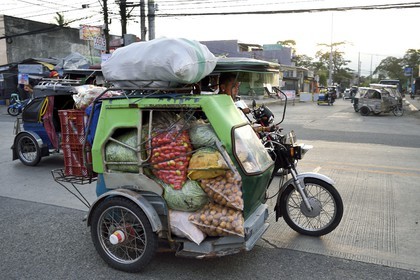 Philippines, province de Nueva Ecija, Bambang, transport de marchandises en tricycle motorisé dans la rue principale