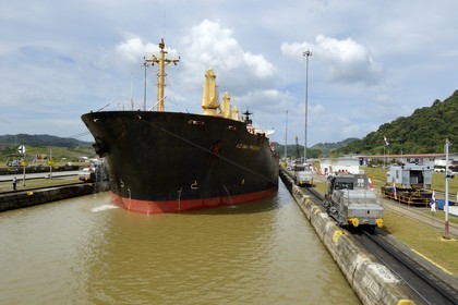 Panama, Canal de Panama, écluses de Pedro Miguel, mules mécaniques ou locomotives électriques guidant un cargo Panamax entre les murs de l'écluse