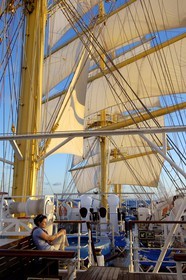 Caraïbes, le SPV Royal Clipper toutes voiles dehors, une passagère contemple le lever de soleil sur le pont supérieur