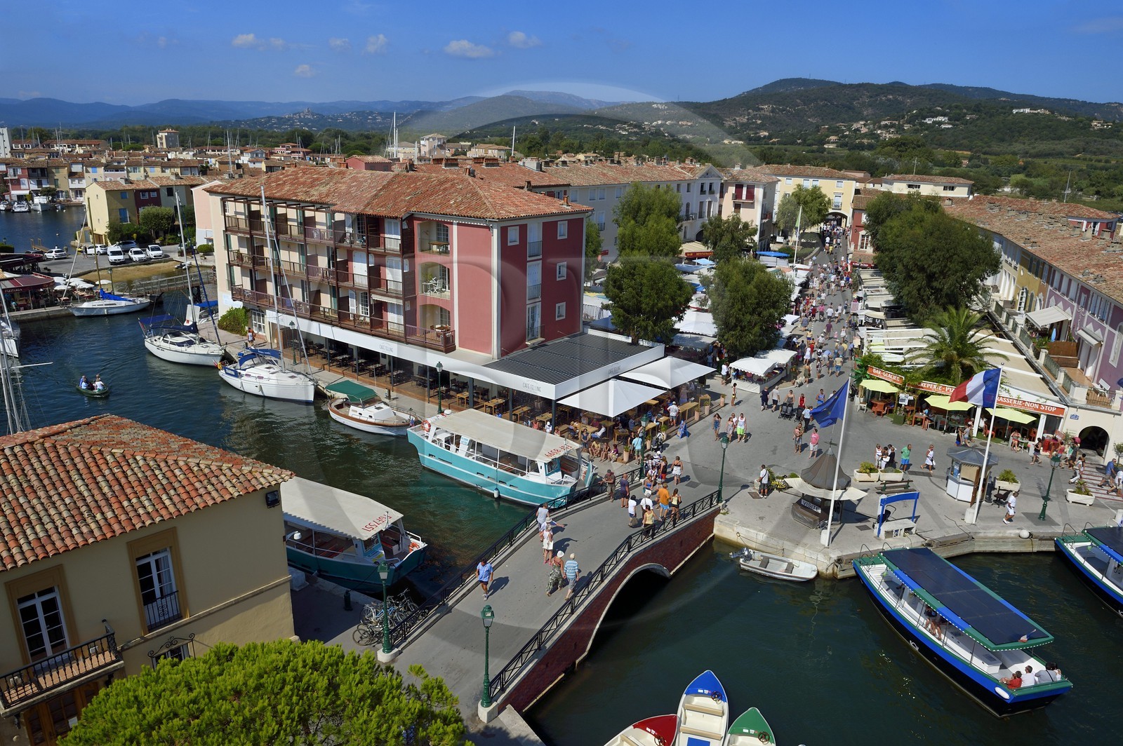 France, Var, Gulf of St Tropez, the Port Grimaud seaside town, the market place and the old village of Grimaud in the background on the left