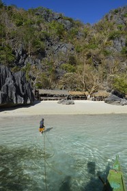 Philippines, Calamian Islands dans le nord de Palawan, Coron Island Natural Biotic Area, plage de Banul Beach au pied des murs géants des falaises de calcaire, batelier