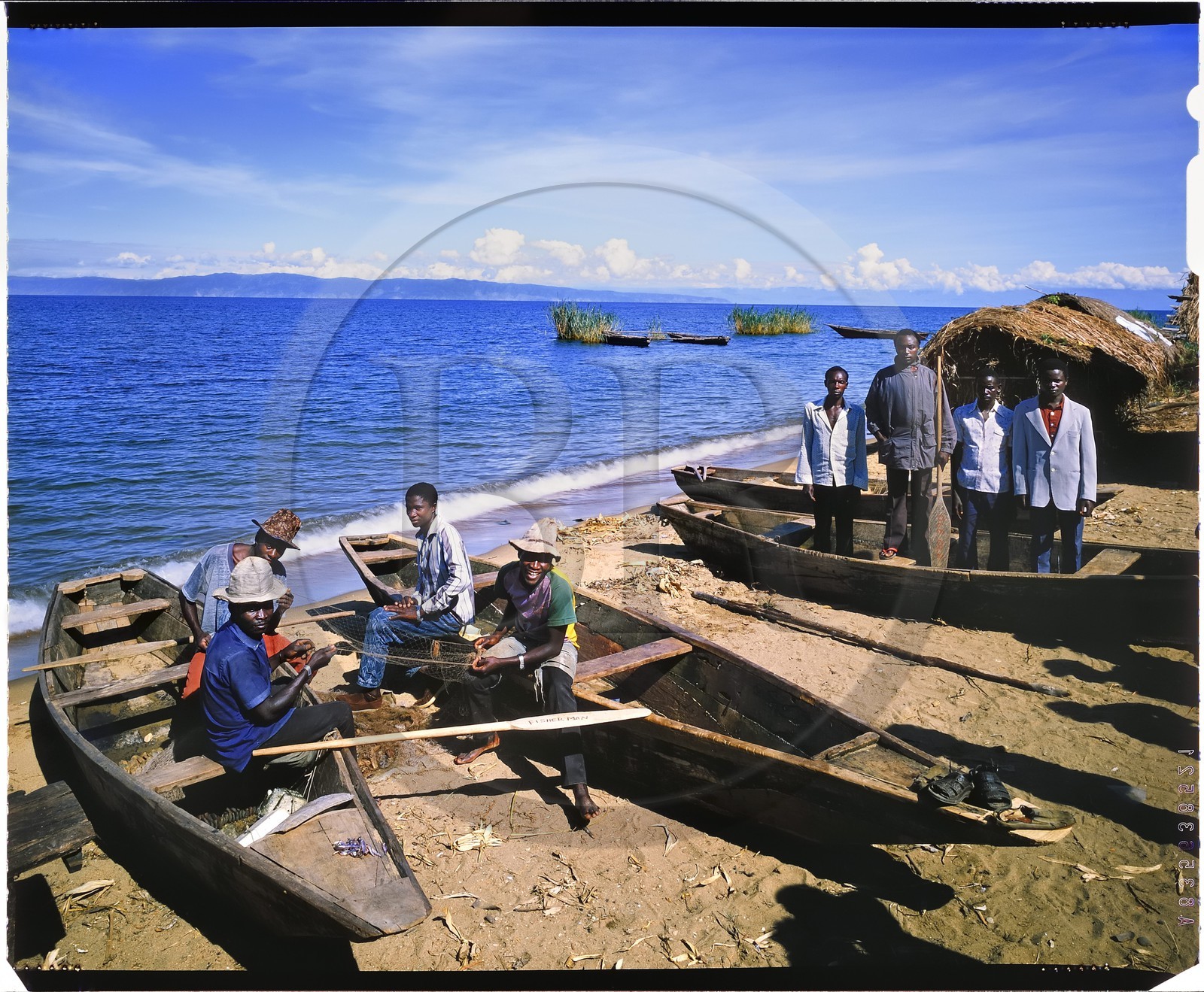 Burundi, Rumonge Province, group of fishermen on Lake Tanganyika, fishermen are exclusively Hutu and come down from the  hills to settle in temporary huts for at least 6 months, fishing is generally done at night with lampara and it's mainly ndagalas (fried fish) mukekes and Lates niloticus, in the background we perceives the tip of Burton and Speke located in the Congo (4x5 reversal film reproduction)