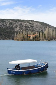 Croatia, Dalmatia, Krka National Park where Krka River becomes Lake Visovac, monk of the Visovac Franciscan Monastery