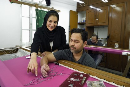 Sultanat d'Oman, Mascate, quartier de Al-Athaiba, atelier de haute couture de Amal Al-Raisi, la fondatrice et la créatrice de mode Amal Al-Raisi avec un de ses brodeurs