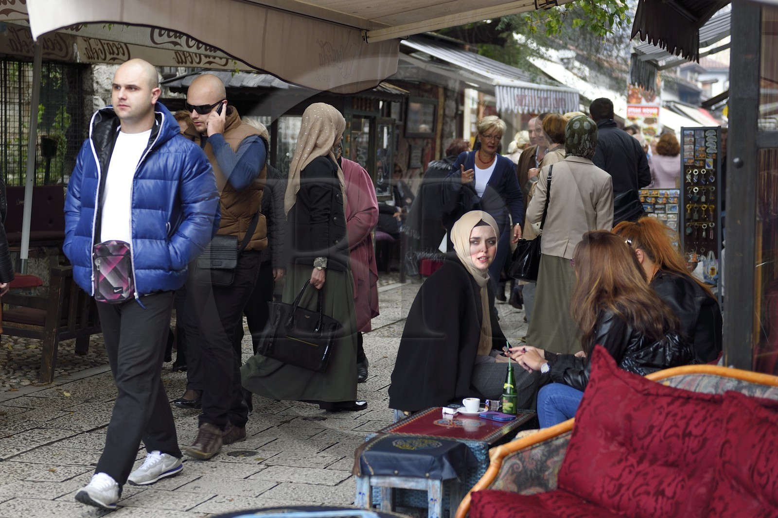 Bosnia and Herzegovina, Sarajevo, Bascarsija district in the old town, Bravadziluk street famous for its Burek and cevapi restaurants, veiled and unveiled girls sitting together at an outdoor cafe