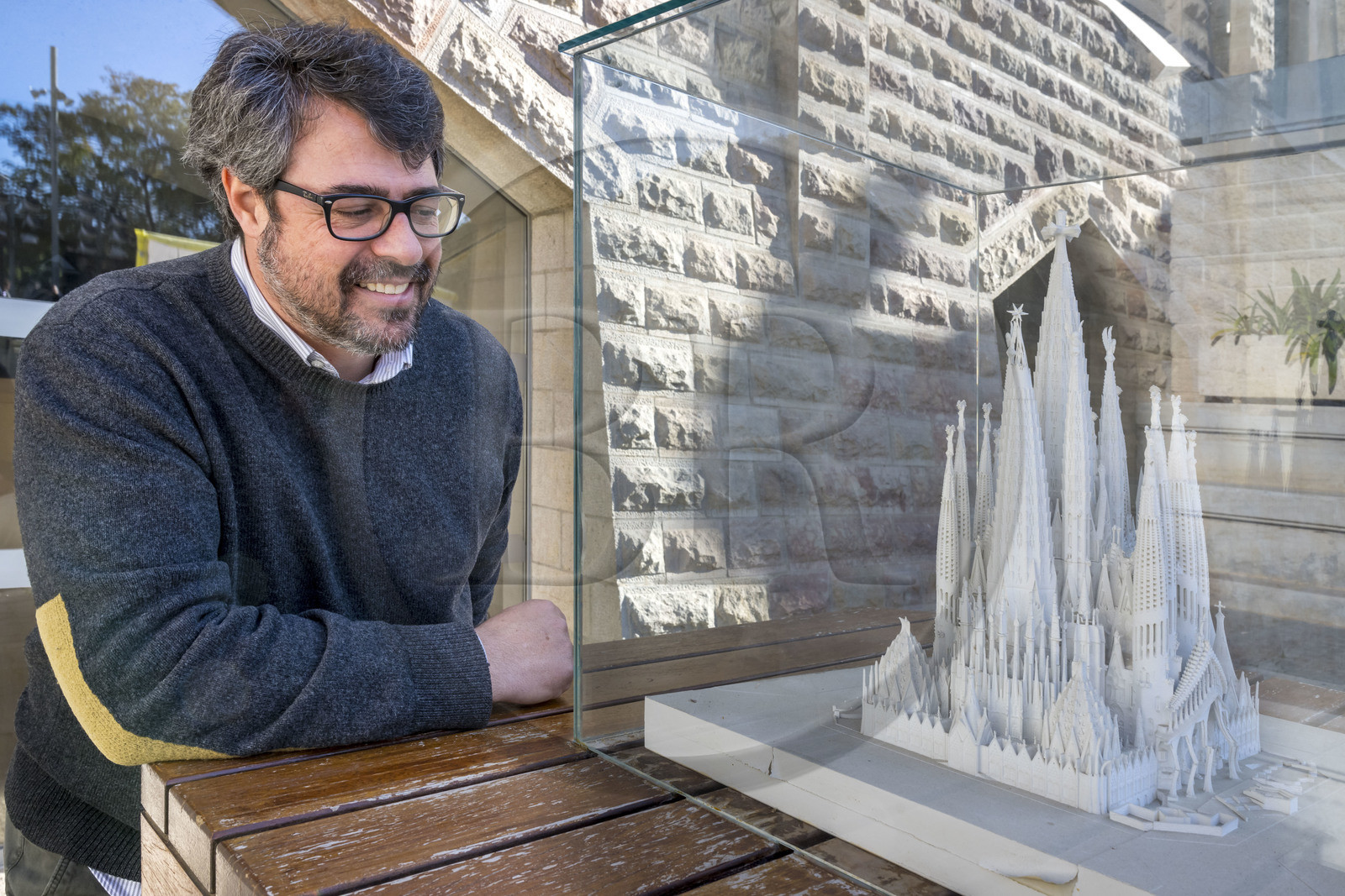 Espagne, Catalogne, Barcelone, quartier de l'Eixample, basilique de la Sagrada Familia de l'architecte du modernisme catalan Antoni Gaudi classée Patrimoine Mondial de l'UNESCO, Xisco Llabrès l'architecte en charge du chantier de la facade nord et du cloitre devant la maquette qui présente le cloitre terminé sous la facade de l'abside