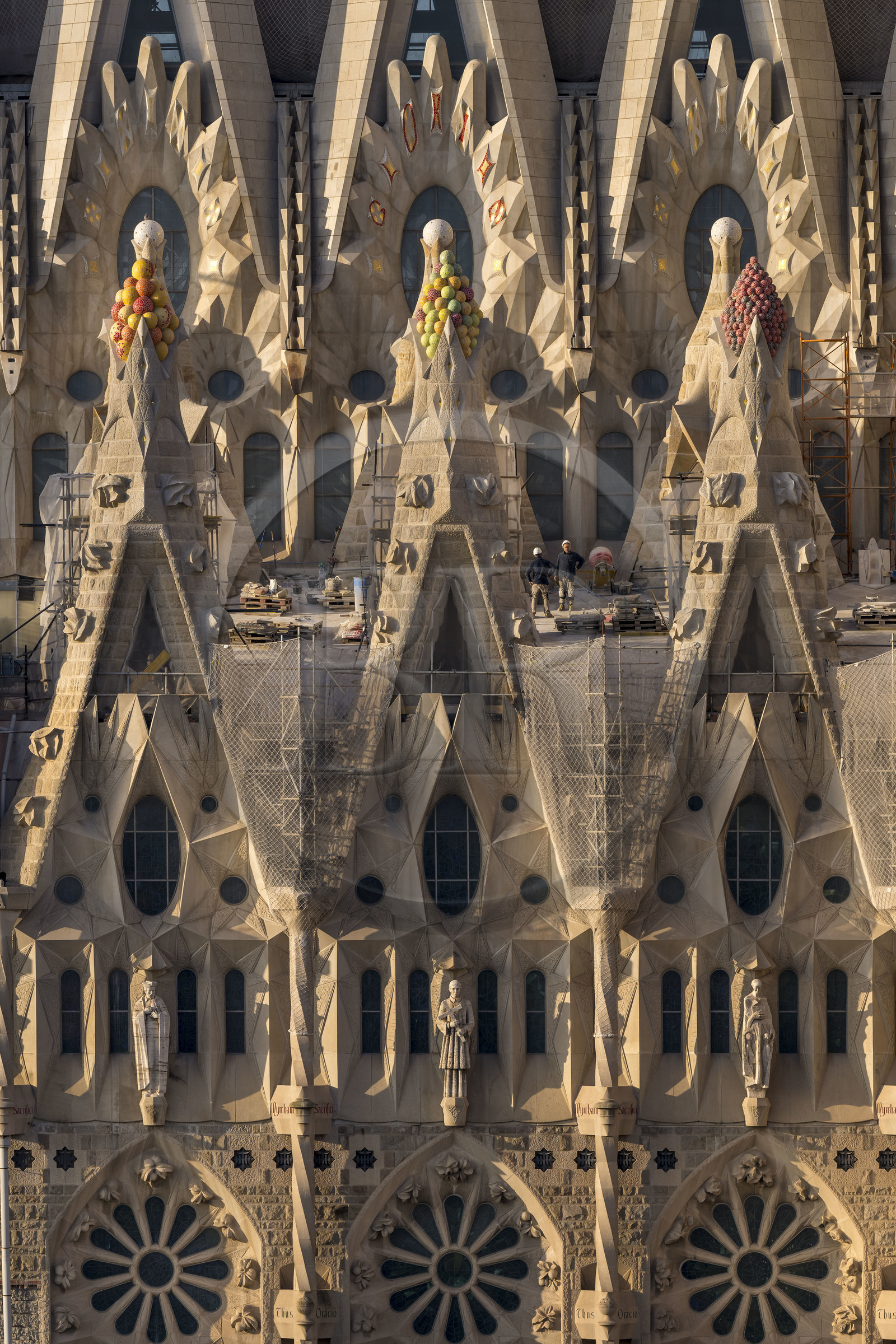 Espagne, Catalogne, Barcelone, quartier de l'Eixample, basilique de la Sagrada Familia de l'architecte du modernisme catalan Antoni Gaudi classée Patrimoine Mondial de l'UNESCO, sommets surmontés de mosaïques en forme de fruits entourant le chantier sur le toit de la nef ici côté facade de la Passion