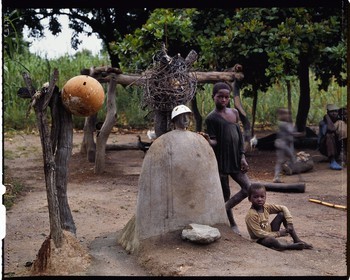 Burkina Faso, province de Poni, pays des Lobi, Loropéni, enfants posant à coté des deux autels principaux de la maison de leur père, liens avec les esprits et les ancetres