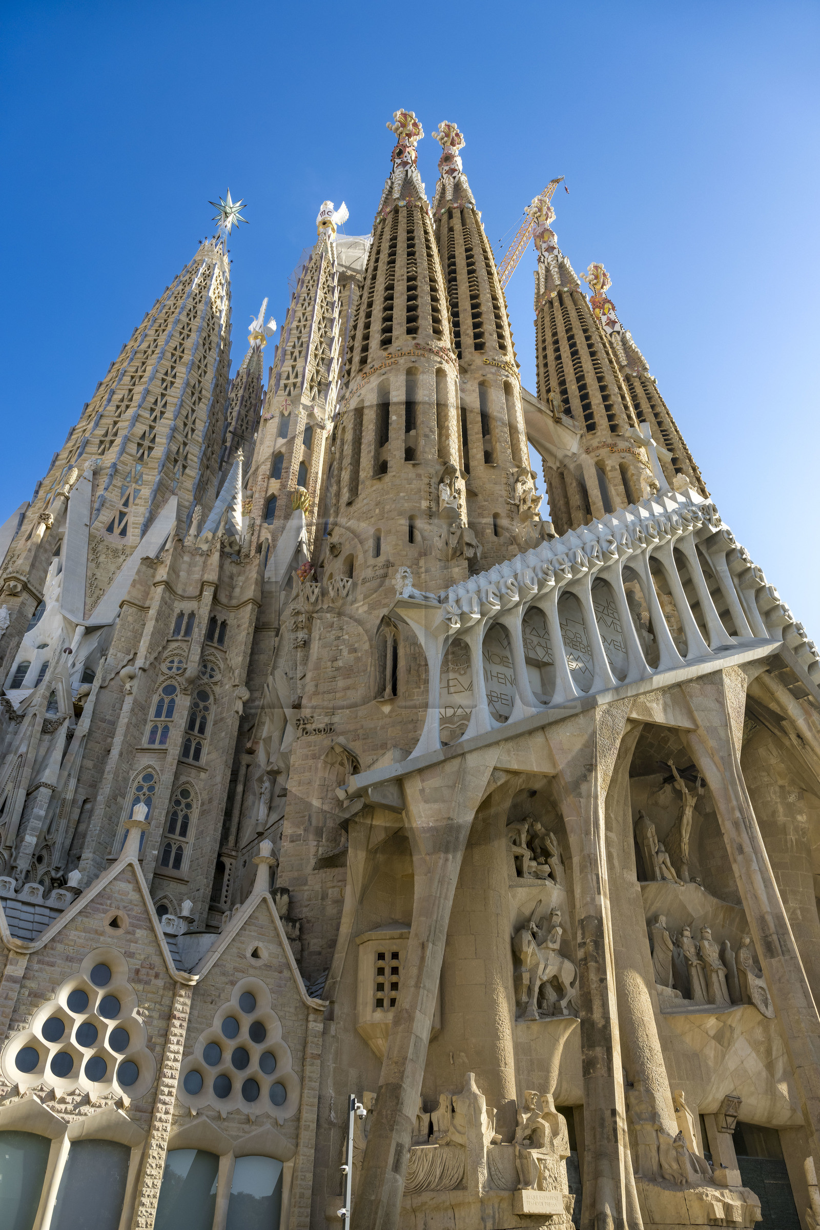 Espagne, Catalogne, Barcelone, quartier de l'Eixample, basilique de la Sagrada Familia de l'architecte du modernisme catalan Antoni Gaudi classée Patrimoine Mondial de l'UNESCO, la façade de la passion dont les sculptures ont été réalisées par Josep Maria Subirachs et l'amorce de la facade de l'abside sur la gauche
