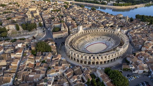 France, Bouches-du-Rhône (13), Arles, les Arènes, amphithéatre romain construit vers 80-90 apr. J.-C. et le théâtre antique du Ier siècle av. J.-C. à gauche, classés Patrimoine Mondial de l'UNESCO, au coeur de la vieille ville et le Rhone en arrière plan (vue aérienne)