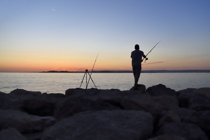 France, Bouches-du-Rhône (13), Marseille, La Madrague, pêcheur au coucher de soleil face au Frioul