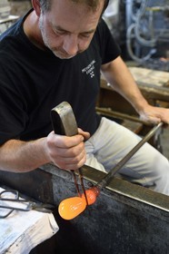 France, Moselle (57), Meisenthal, Centre international d’Art verrier (CIAV), l'atelier de soufflage, fabrication artisanale d'une boule de Noël, le souffleur et maitre verrier Jean-Marc Schilt régularise la masse au marbre tout en effectuant une rotation continue de sa canne et préparation de la paraison avant le passage au moule