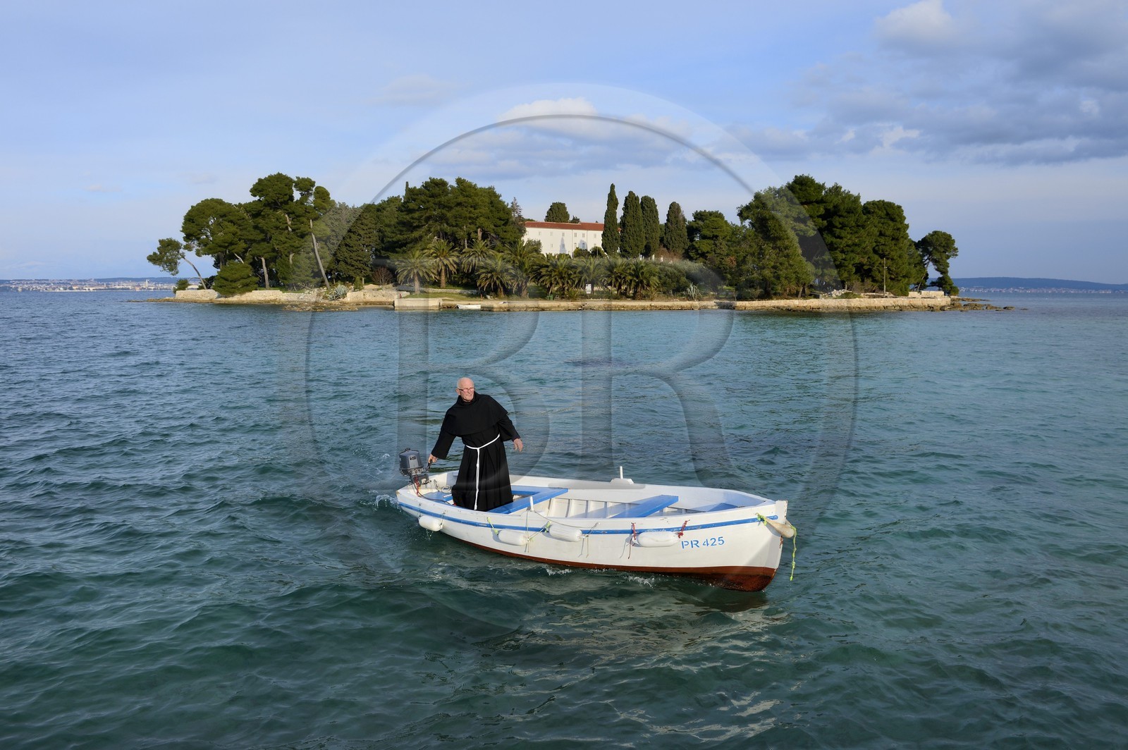 Croatie, Dalmatie, côte dalmate, Ile d’Ugljan, Preko, le frère franciscain Bozo Susic quittant le Monastère Franciscain de l'îlot Galovac sur sa barque