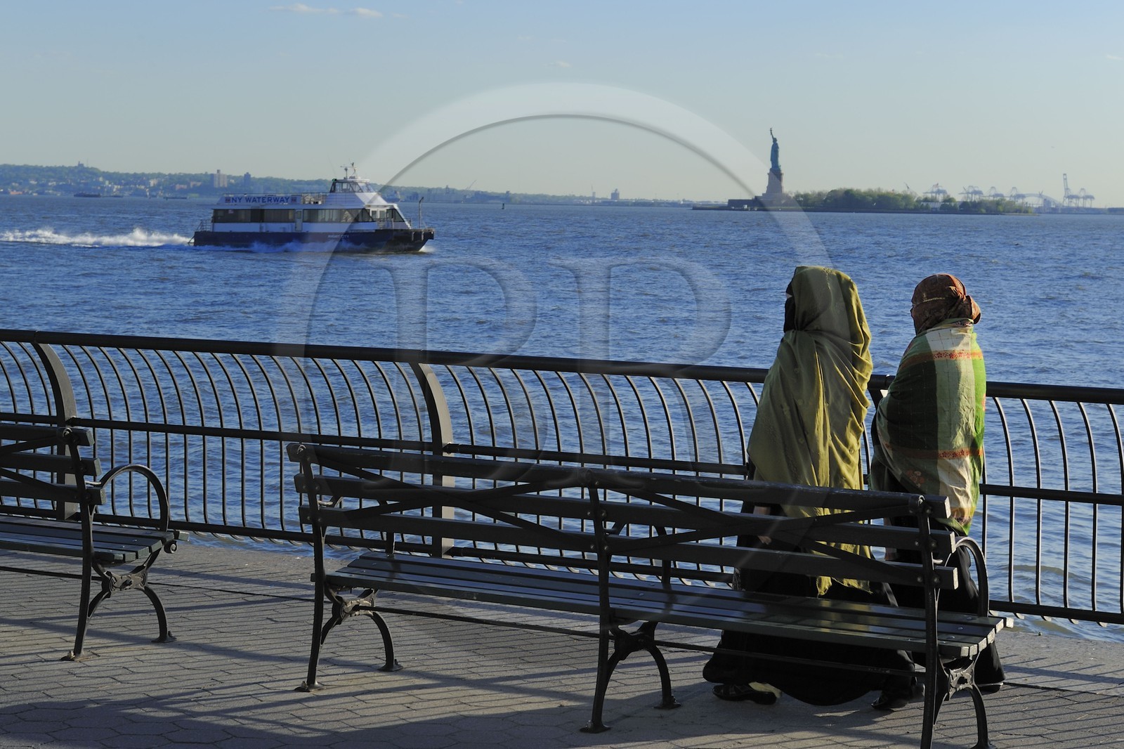 United States, New York City, Manhattan, South Point, Battery Park, veiled women walking along Battery Park and the Statue of Liberty in the background