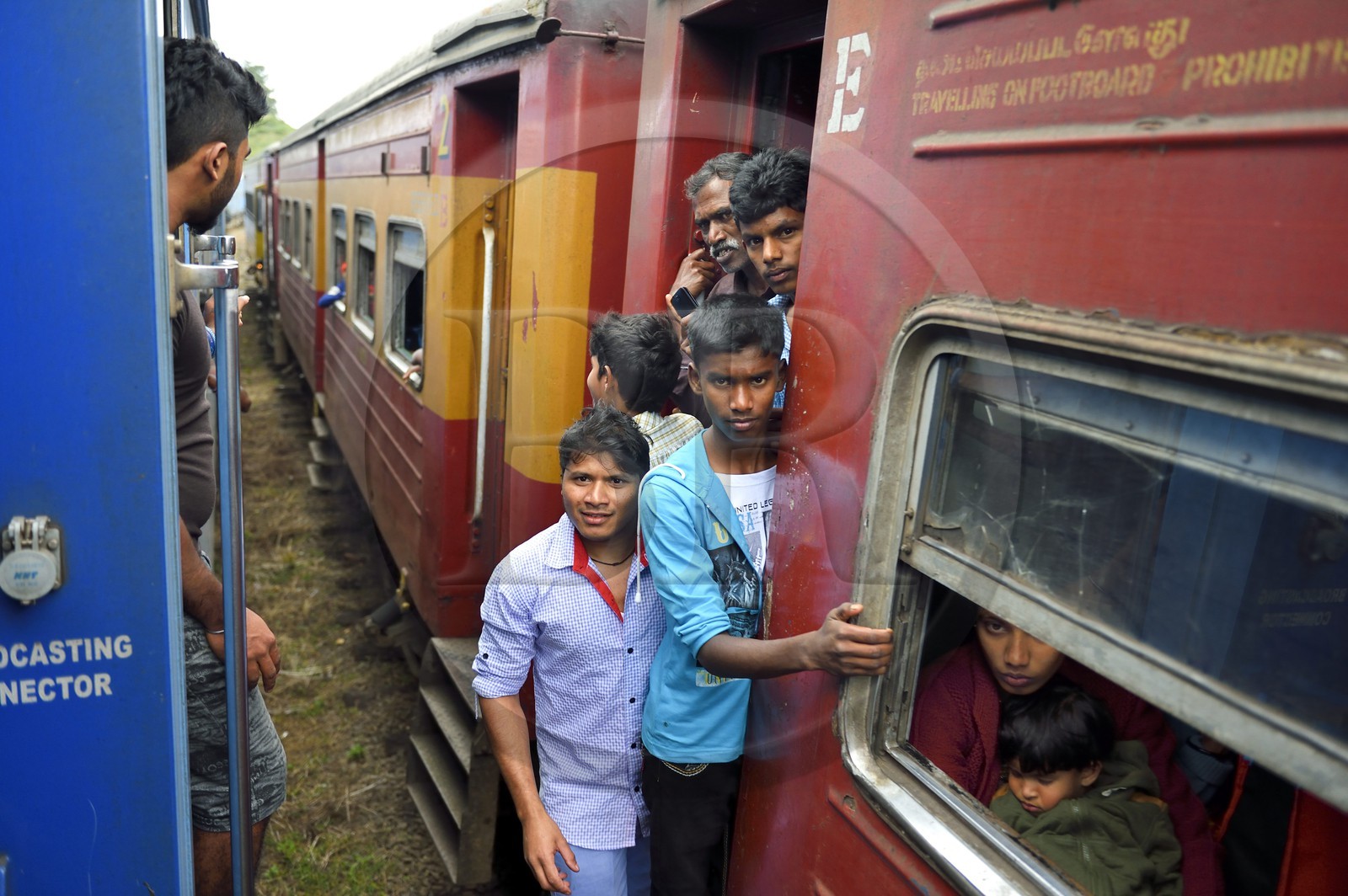 Sri Lanka, Central Province, the popular scenic train ride through the tea growing hill country between Hatton and Badulla, Great Western train station, passengers hanging on the door