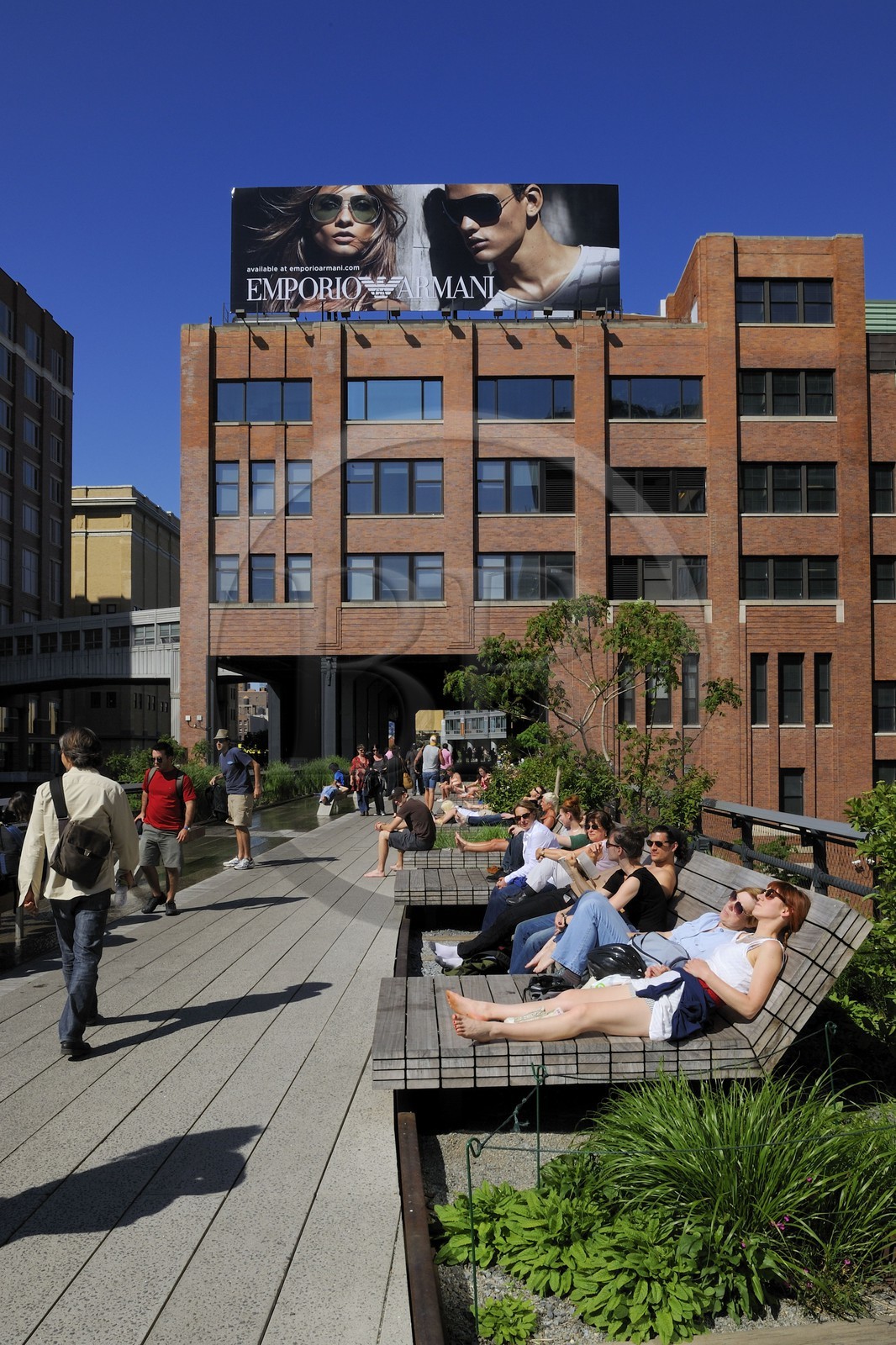 Etats-Unis, New York, Manhattan, Meatpacking district (Gansevoort Market), le High Line Park est une ancienne voie-ferrée aérienne partiellement réhabilitée en parc urbain suspendu, où la voie ferrée traversait le deuxième étage de l'immeuble Chelsea Market et personnes se reposant sur des chaises longues