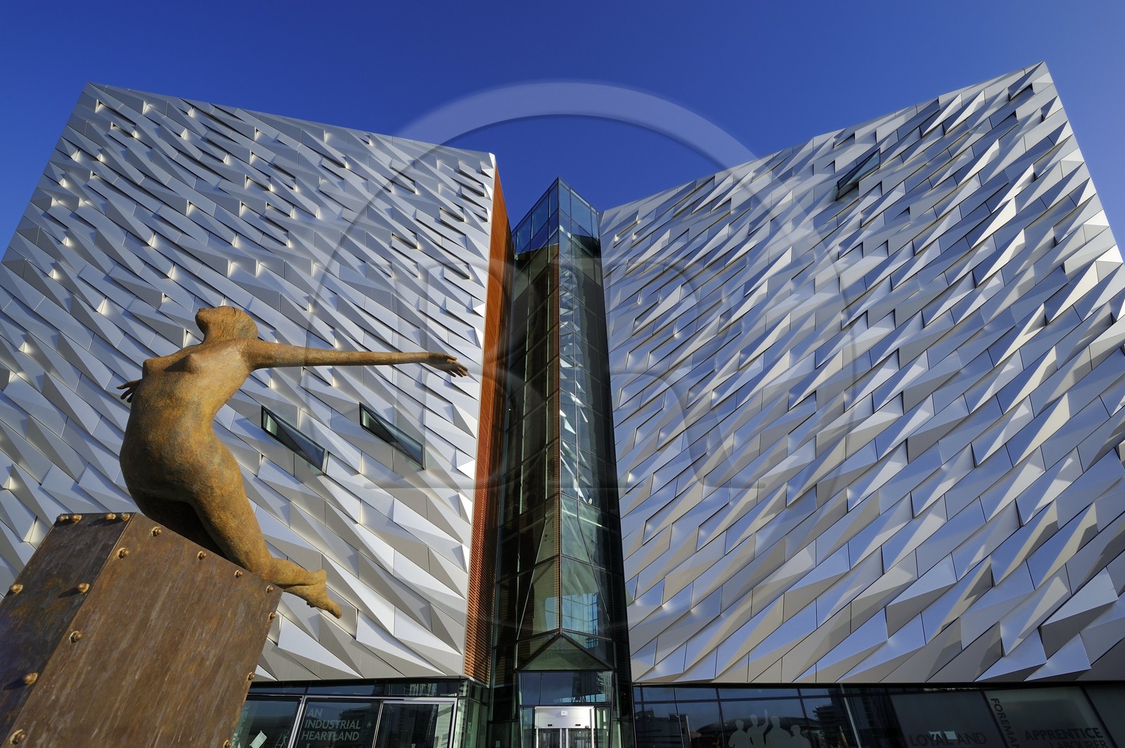 Royaume-Uni, Irlande du Nord, Belfast, quartier des docks de Queen's Island, la sculpture Titanica par l'artiste Rowan Gillespie devant le batiment du centre Titanic Belfast Experience