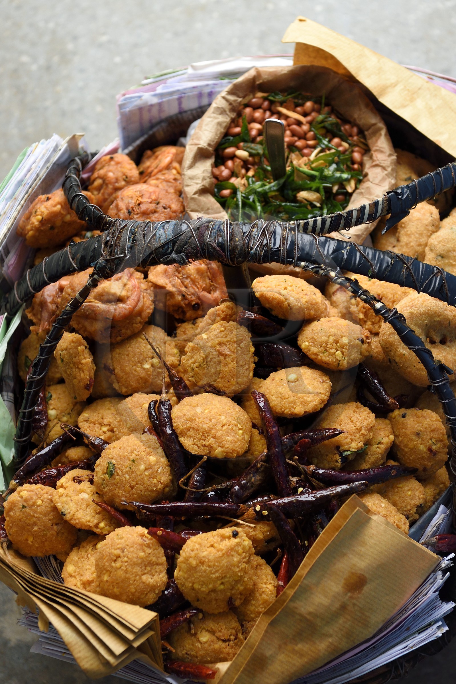 Sri Lanka, Province d'Uva, trajet en train dans la région montagneuse de la culture du thé entre Hatton et Ella, gare de Idalgashinna, panier d'un vendeur ambulant de beignets de crevettes et de wade