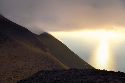 Italie, Sicile, iles Eoliennes, classées Patrimoine Mondial de l'UNESCO, ile de Stromboli, fumerolles et nuages sur les pentes du volcan actif au coucher de soleil