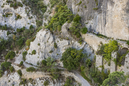France, Hérault (34), Causses et les Cévennes, paysage culturel de l'agro-pastoralisme méditerranéen, classés Patrimoine Mondial de l'UNESCO, Saint-Guilhem-le-Désert, labellisé Les Plus Beaux Villages de France, randonneurs sur la Via Tolosana sur le Chemin de Saint-Jacques-de-Compostelle, le passage des Fenestrelles aménagé au Moyen-age par les moines de l'abbaye afin de franchir ce verrou rocheux dans le cirque de l'Infernet