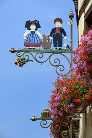France, Haut-Rhin (68), Eguisheim, labellisé Les Plus Beaux Villages de France, enseigne de boulangerie avec des personnages en costume alsacien