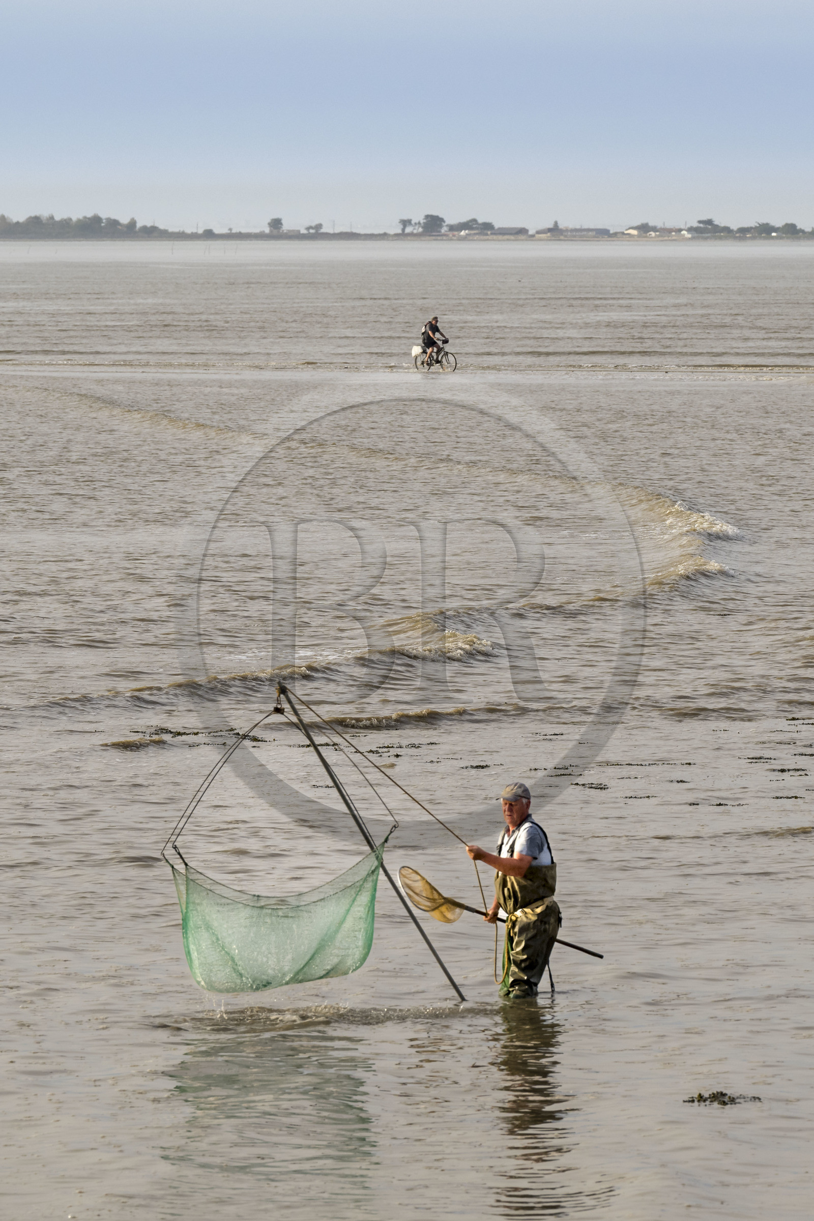 France, Charente-Maritime (17), Port-des-Barques, pêcheur au carrelet et cycliste empruntant le tombolo de la Passe aux Boeufs qui relie le continent à l'Ile Madame à marée montante en arrière plan