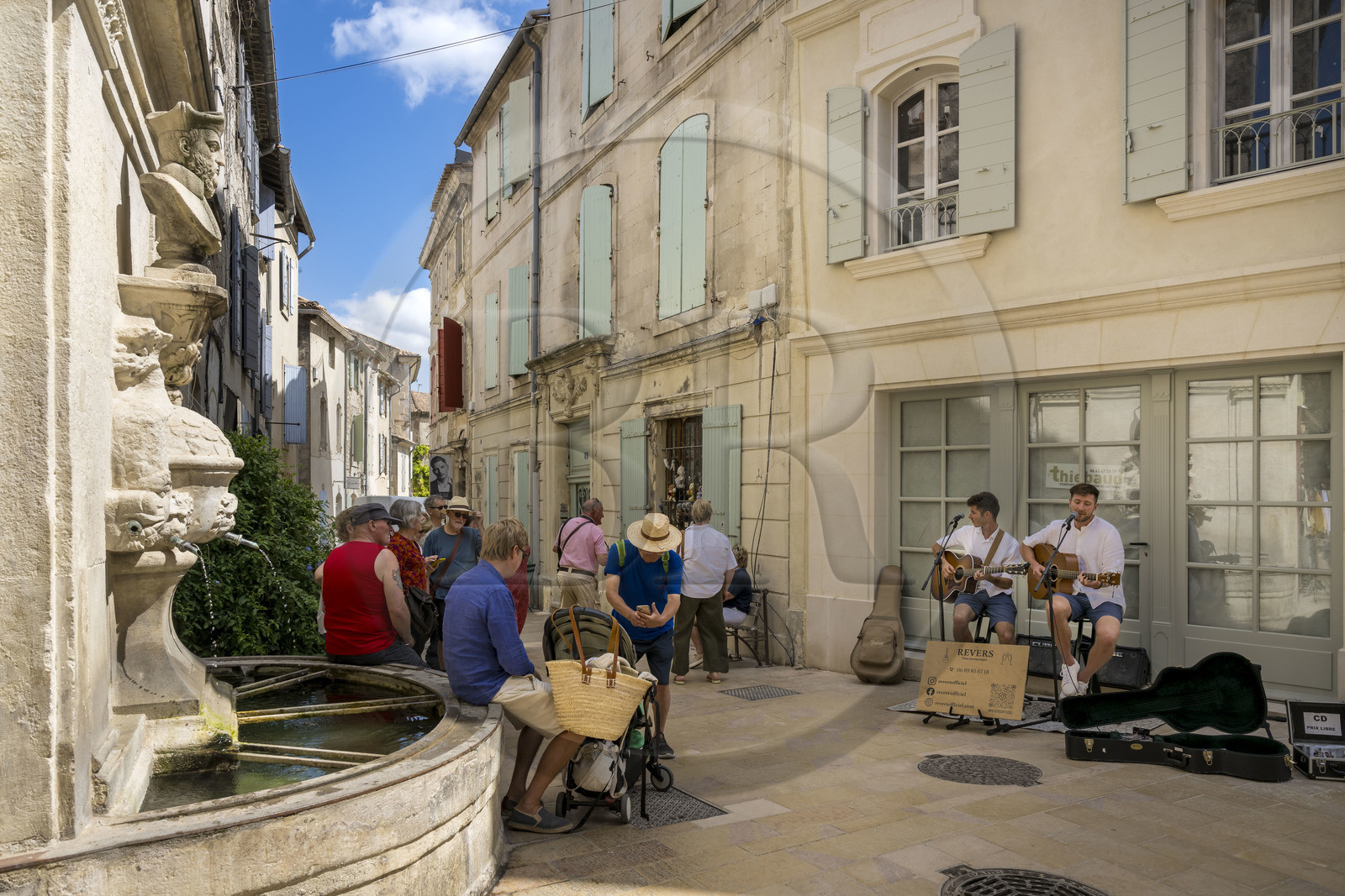 France, Bouches-du-Rhône (13), Parc Naturel Régional des Alpilles, Saint-Rémy-de-Provence, les musiciens de rue du duo acoustique Revers chantent devant la fontaine Nostradamus