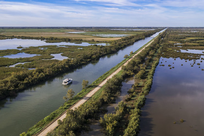 France, Gard (30), la Petite Camargue, navigation d'un bateau de plaisance Le Boat sur le canal du Rhône à Sète entre Gallician et Aigues-Mortes (vue aérienne) France, Gard, the Petite Camargue, navigation of a pleasure boat Le Boat on the Rhone to Sète Canal between Gallician and Aigues-Mortes (aerial view)