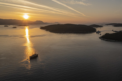 Croatia, Dalmatia, Dalmatian coast, boat sailing at dawn towards archipelago Skoji in the strait between the Peljesac peninsula and Korcula Island (aerial view)