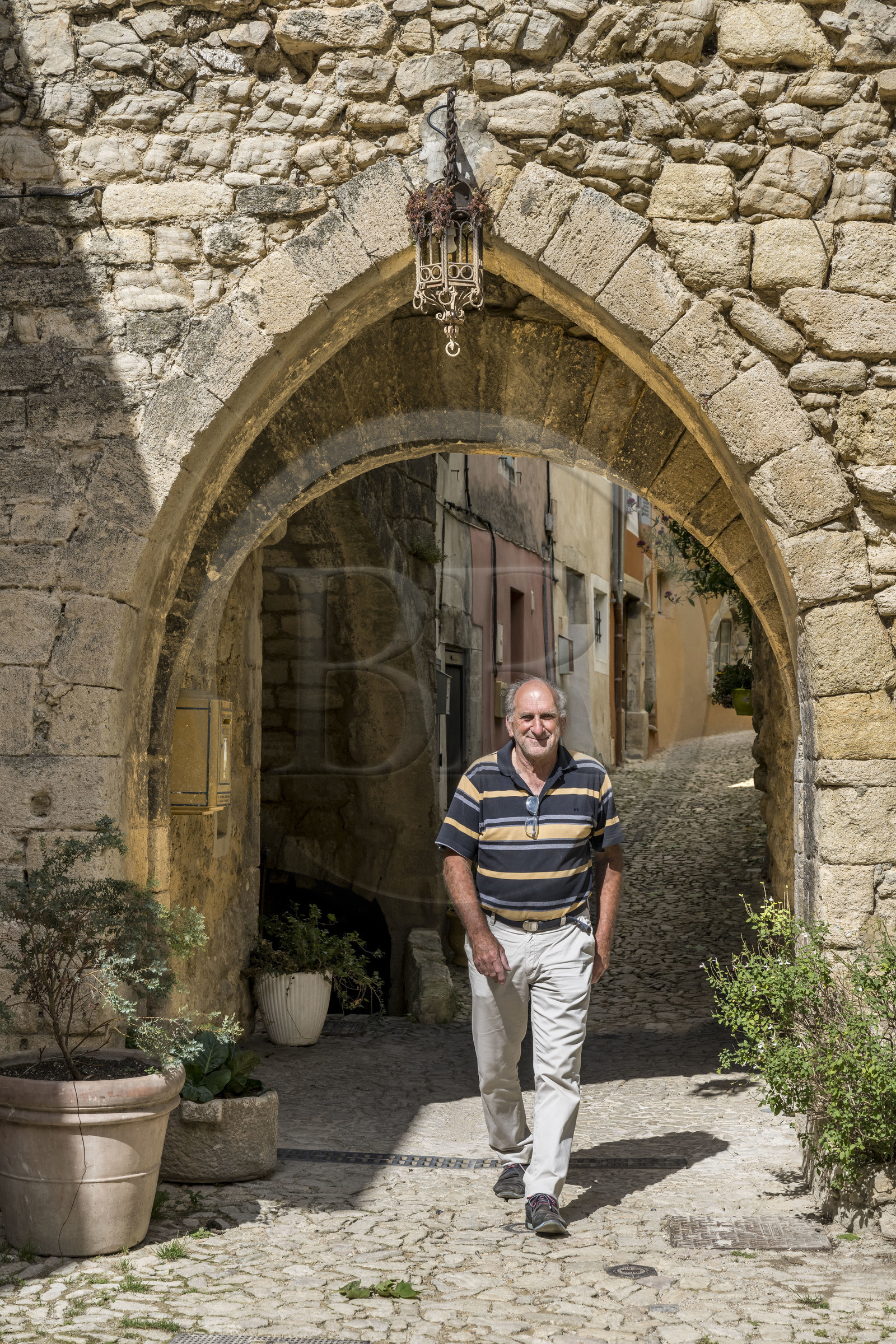 France, Drome, regional natural park of Baronnies provencales, Montbrun les Bains, labeled the Most Beautiful Villages of France, old gate of the ramparts at the entrance to the medieval village Place du Beffroi, Gérard Chappon, deputy mayor of the commune and amateur historian