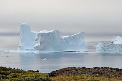 Groenland, cote ouest, Ile de Disko, Qeqertarsuaq, bateau entre deux icebergs le long de la côte