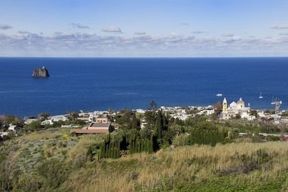 Italie, Sicile, iles Eoliennes, classées Patrimoine Mondial de l'UNESCO, ile de Stromboli, le village de Stromboli et l'ilot de Strombolicchio, roche de magma solidifié provenant d'un ancien bouchon volcanique, en arrière plan