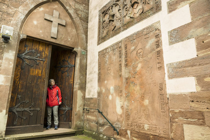 France, Bas-Rhin, Parc regional des Vosges du nord (Northern Vosges Regional Natural Park), La Petite Pierre, the simultaneous Church of Our Lady alternating between Catholic and Protestant worship, tombstones are affixed against the exterior wall