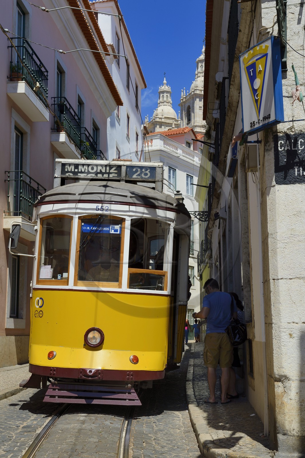Portugal, Lisbon, Alfama district, tram (electricos) along Rua das Escolas Gerais with the tower of Sao Vicente de Fora church