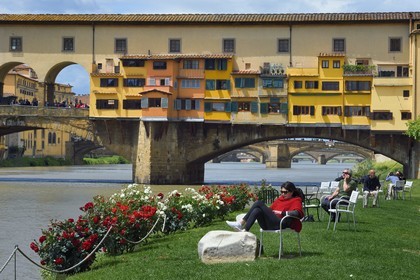Italy, Tuscany, Florence, listed as World Heritage by UNESCO, the Ponte Vecchio seen from the Societa Canottieri Firenze (Florence Rowing Club), club members having a rest on the edge of the Arno River