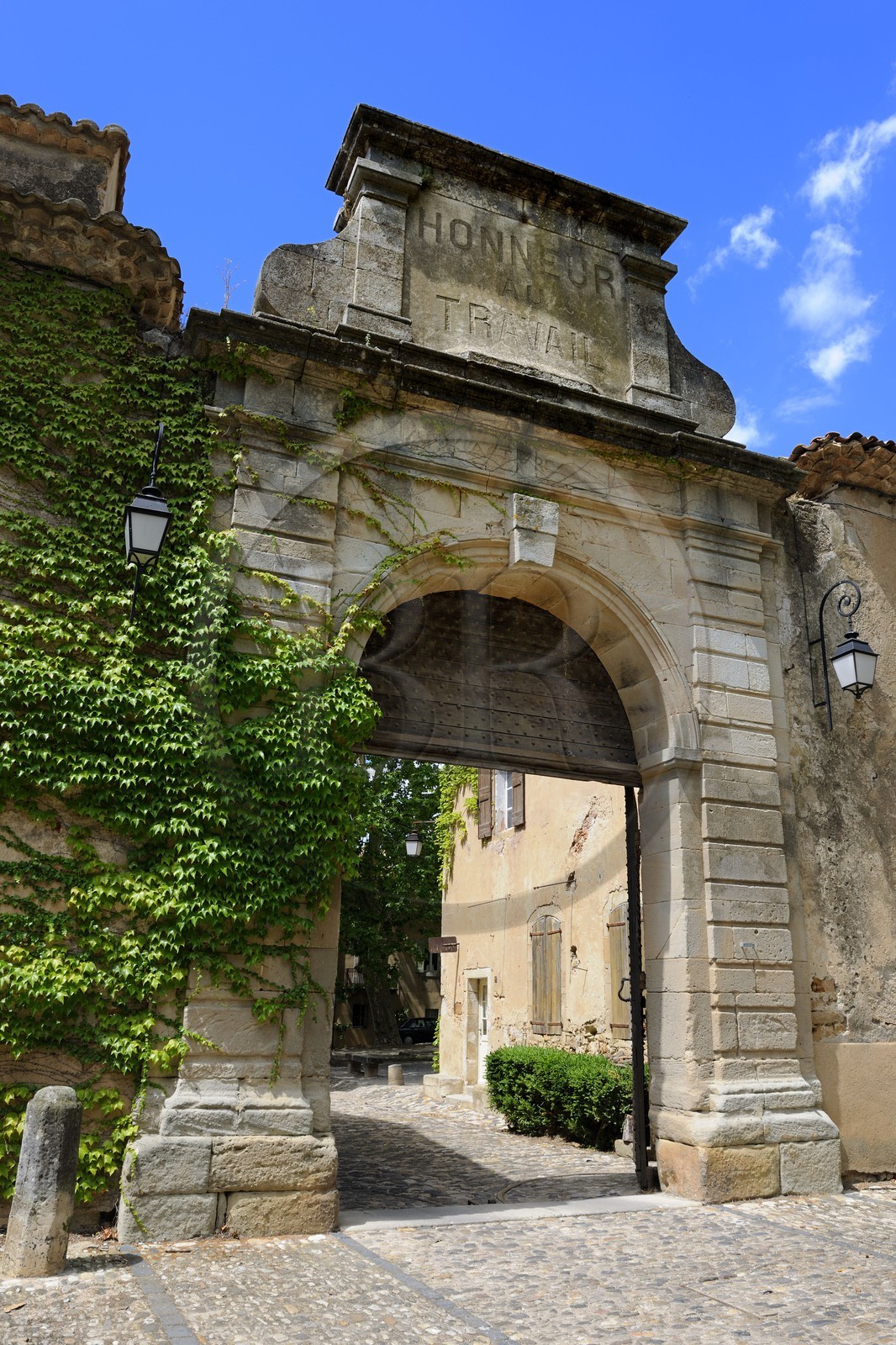 France, Herault, Villeneuvette, main gate of the former royal factory, on the pediment we can see the words Honor to work