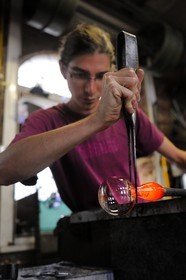 France, Moselle (57), Meisenthal, souffleur au Centre international d’Art verrier (CIAV), fabrication d'une boule de Noël en verre. La canne de verre posée sur un banc appelé « gamin mécanique », Thibaut crée avec la pince l’étranglement