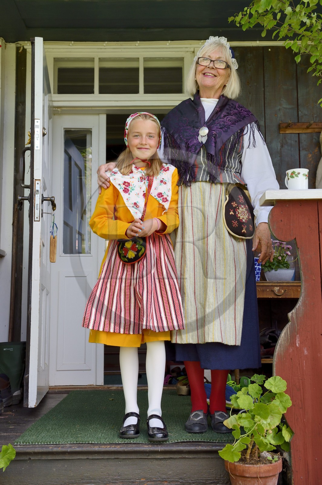 Suède, comté de Dalécarlie, région de Leksand, grand-mère et sa petite fille en costumes traditionnels pour les célébrations du solstice d'été dans le petit hameau de Sunnanäng