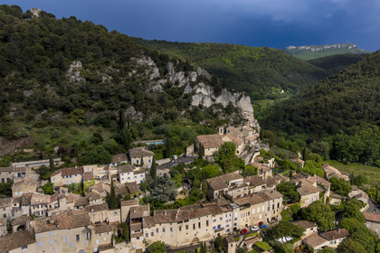 France, Vaucluse, Dentelles de Montmirail mountains, the medieval village of Séguret, labelled Les Plus Beaux Villages de France (The Most Beautiful Villages of France), on a stormy day and the Saint-Amand ridge seen from the south in the background (aerial view)
