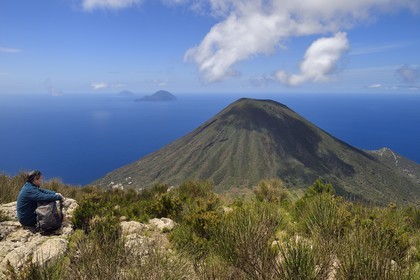 Italie, Sicile, iles Eoliennes, classées Patrimoine Mondial de l'UNESCO, Ile de Salina, randonneur au sommet de l'ancien volcan Monte Fossa delle Felci observant le volcan jumeau Monte dei Porri, les Iles de Filicudi et d'Alicudi en arrière plan