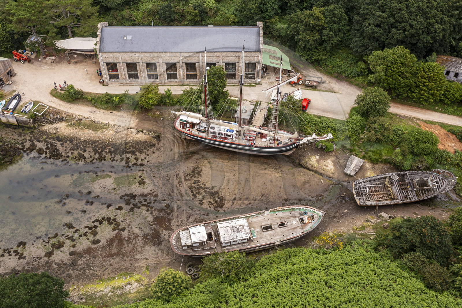 France, Finistère (29), Pays des Abers, Aber Wrac'h, Lannilis, le Moulin de l'Enfer, chantier naval de l'association AJD (association Amis de Jeudi-Dimanche) fondée par le Père Jaouen, l'épave de la goélette à trois mâts et hunier le Bel Espoir II à au premier plan et le nouveau Bel Espoir II à coque en acier derrière (vue aérienne)