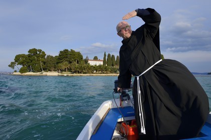 Croatie, Dalmatie, côte dalmate, Ile d’Ugljan, Preko, le frère franciscain Bozo Susic quittant le Monastère Franciscain de l'îlot Galovac sur sa barque